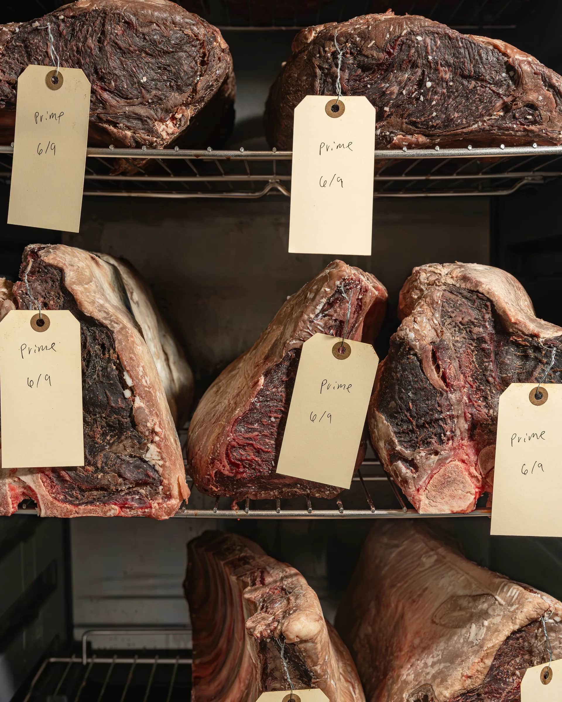 Dry-age room shelves with tagged prime beef