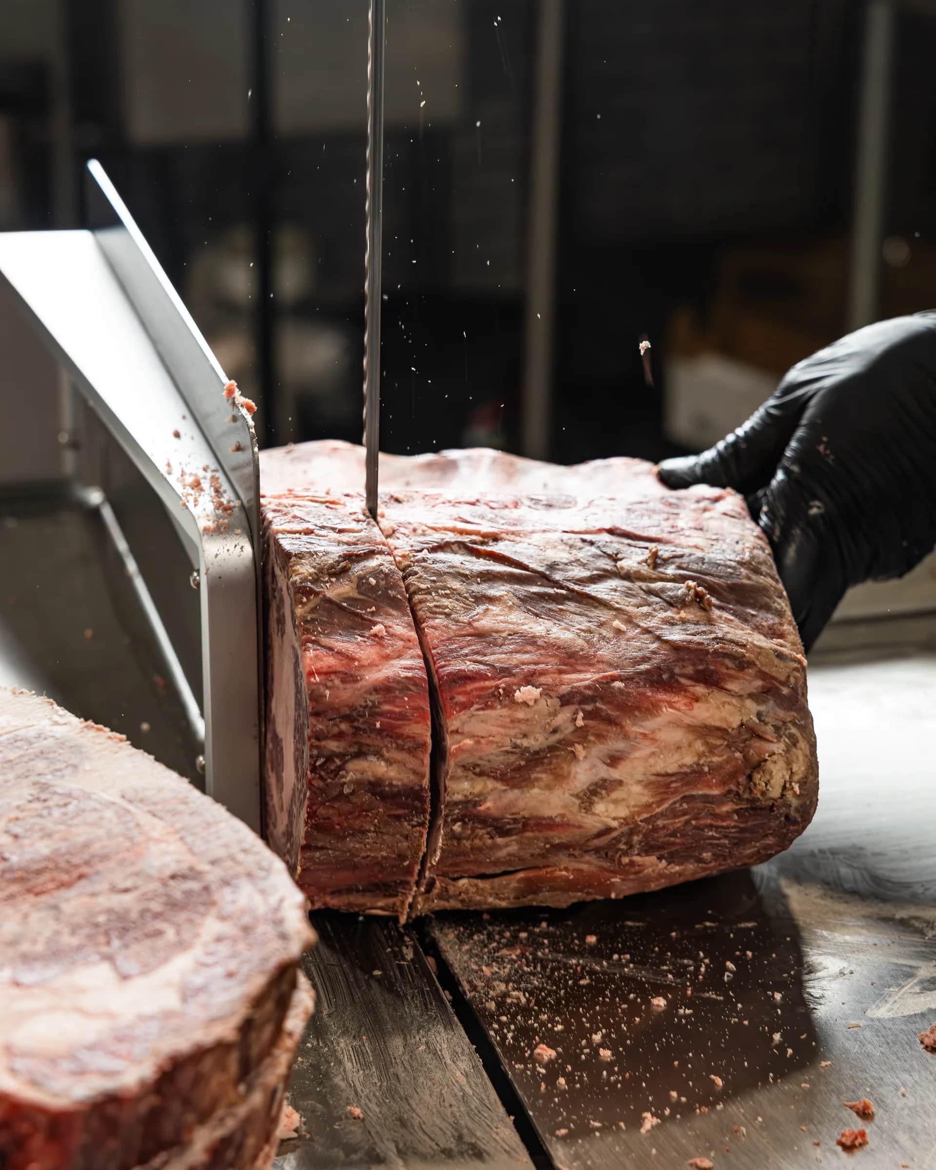Band saw cutting a large beef roast