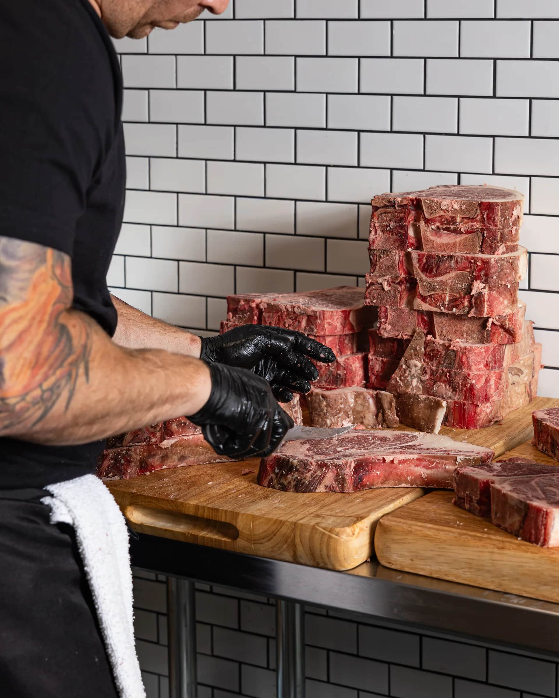 Butcher arranging a stack of short ribs