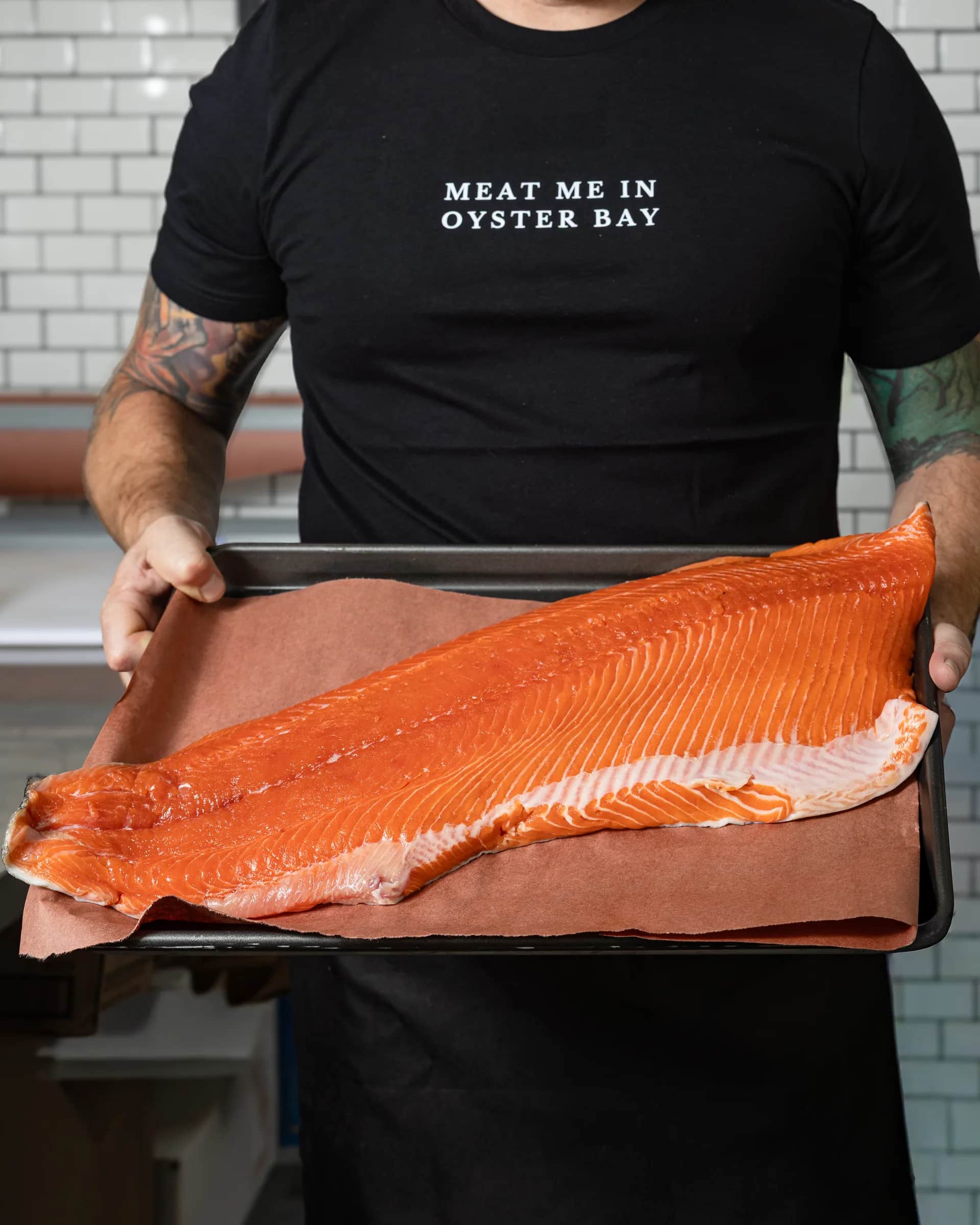 A whole salmon fillet on butcher paper presented at the counter